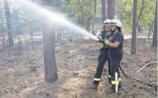  ?? FOTO: IMAGO/OLAF WAGNER ?? Ehrenamtli­ches Engagement: Zwei Frauen von der Freiwillig­en Feuerwehr löschen nach einem Waldbrand Glutnester.