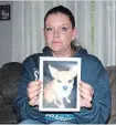 ?? KRIS DUBE
THE WELLAND TRIBUNE ?? Erin Clarke holds a photo of her chihuahua Thor who died after being attacked by three dogs.