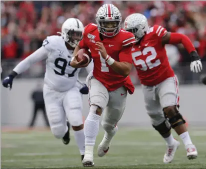  ?? JAY LAPRETE — THE ASSOCIATED PRESS ?? Ohio State quarterbac­k Justin Fields, center, runs for a first down against Penn State during the first half on Saturday in Columbus, Ohio.