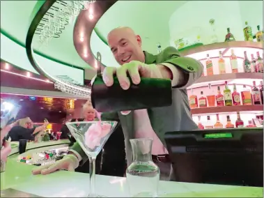  ?? WAYNE PARRY/AP PHOTO ?? Bartender Chip Glaeser pours a drink at the opening of a new rotating 360-degree bar at Bally’s casino in Atlantic City, N.J., on Thursday. This summer is a crucial one for Atlantic City as it seeks to make up lost economic ground in the third year of the coronaviru­s pandemic.