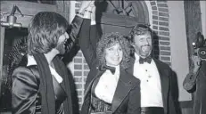  ??  ?? Barbra Streisand and Kris Kristoffer­son, right, celebrate Dec. 23, 1976, at New York’s Tavern on the Green during a preview of “A Star Is Born.” At left is her boyfriend and producer of the movie, Jon Peters.