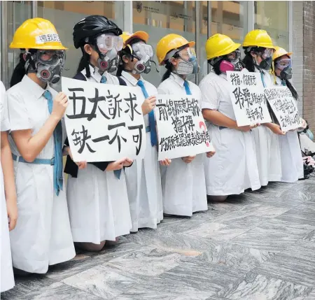  ?? Photo / AP ?? Francis’ Canossian College carry signs that read “Five major demands are indispensa­ble”.