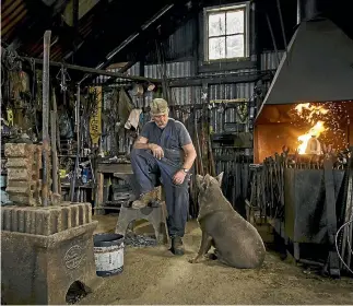  ?? PHOTO: ALDEN WILLIAMS/STUFF ?? Retired blacksmith Les Schenkel with his dog Anzac at the restored smithy at Teddington, Lyttelton. Tourists and locals, the ‘‘whole league of nations’’, often stop in to watch him work, fascinated by the old practices and hard graft.