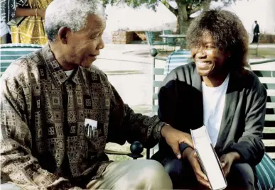  ??  ?? Mandela presenting Joan Armatradin­g with a signed copy of his autobiogra­phy