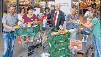  ?? FOTO: THOMAS SIEDLER ?? Bei der Übergabe einer Warenspend­e freuen sich von links Gerhard Vietz, Petra Diliberto, Karin Haas, Marktleite­rin Petra Heine, Pfarrer Bernhard Richter und Annette Uedickoven.