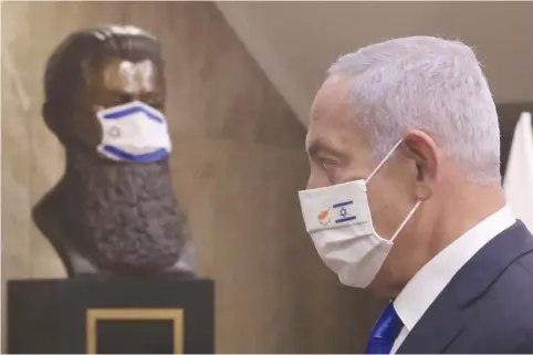  ?? (Marc Israel Sellem/The Jerusalem Post) ?? BENJAMIN NETANYAHU passes by a masked statue of Theodor Herzl in the Prime Minister’s Office in Jerusalem.