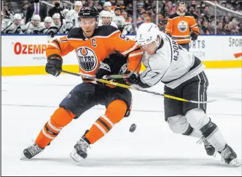  ?? The Associated Press ?? Jason Franson
Kings defenseman Tobias Bjornfot tries to push Oilers center Connor Mcdavid off the puck in the second period of Los Angeles’ 5-1 victory Sunday at Rogers Place.