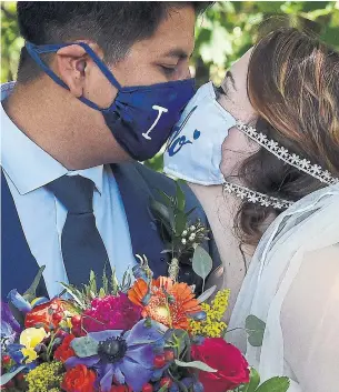  ?? OLIVIER DOULIERY AFP VIA GETTY IMAGES ?? Rachel and Sebastian Vasquez share their first kiss as husband and wife this month in Rustburg, Va. For some couples, social distancing restrictio­ns have taken the pressure off of planning.