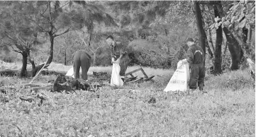  ??  ?? Some of the workers picking up litter at areas unreachabl­e by the machine.