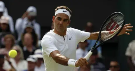  ?? ALASTAIR GRANT/THE ASSOCIATED PRESS ?? Roger Federer returns to Alexandr Dolgopolov during their very short first-round match at Wimbledon on Tuesday. Dolgopolov retired with an injury.