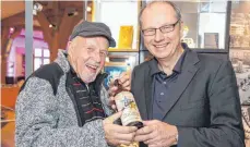  ??  ?? Gerd Maier (l.) und Frank Brunecker stellen die Whiskyflas­che in die Vitrine im Biberacher Museum.
