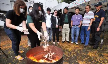  ?? REYNAN VILLENA ?? Regional Trial Court Judge Macaundas Hadjirasul (3rd from right) and Philippine Drug Enforcemen­t Agency-7 Officer-in-charge Esperidion Javier (4th from right) led the burning of illegal drugs kept in the judge’s sala as evidence.