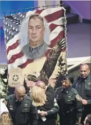  ?? Travis Spradling Pool Photo ?? IN BATON ROUGE, mourners line up to honor Brad Garafola, an off-duty sheriff ’s deputy who ran to help police officers under fire and was fatally shot.