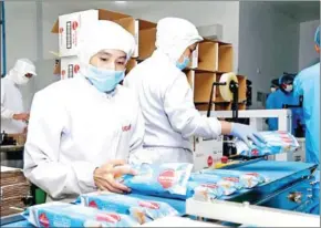  ?? SUPPLIED ?? Workers are packing chips at LyLy Food in Phnom Penh’s Por Sen Chey district.