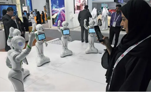  ?? Photos by Shihab ?? A visitor captures moments of robots performing a traditiona­l UAE dance at the Gitex Technology Week. —