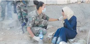  ?? (Lebanese Army/Reuters) ?? A LEBANESE SOLDIER speaks with a Syrian refugee in Arsal, near the Syrian border, on July 24.