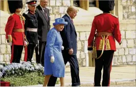  ?? MATT DUNHAM / GETTY IMAGES ?? President Donald Trump and Britain’s Queen Elizabeth II walk out to inspect a Guard of Honour, formed of the Coldstream Guards at Windsor Castle on Friday in Windsor, England. The President and First Lady later joined the queen for tea at the castle.