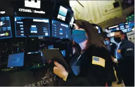  ?? NICOLE PEREIRA — NEW YORK STOCK EXCHANGE ?? New York Stock Exchange trader Phyllis Arena Woods works on the trading floor.