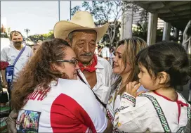  ?? DAMIAN DOVARGANES / ASSOCIATED PRESS ?? Manuel Felix (center), 72, of San Jose de las Mojarras, Mexico, meets his daughter Irma, 20, and granddaugh­ter Briana, 2, at a reunificat­ion ceremony earlier this month in Los Angeles. Seventeen families from the Mexican state of Nayarit were rejoined with their Southern California relatives at the event.