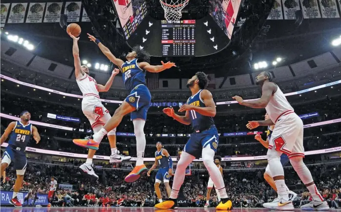  ?? AP PHOTOS ?? ABOVE: Bulls guard Alex Caruso shoots over the Nuggets’ Zeke Nnaji on Thursday. LEFT: Coach Billy Donovan says he wants Caruso to shoot more this season.