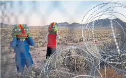  ?? JOHN LOCHER THE ASSOCIATED PRESS ?? Martin Custodio, left, and Rafael Castillo wear Pepe masks near an entrance to the Nevada Test and Training Range near Area 51, Sept. 20, near Rachel, Nev.