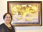  ??  ?? Aklan artist Anna India dela Cruz-Legaspi weaves the magic of piña into her exquisite works of art. Beside her is her koi watercolor painting.