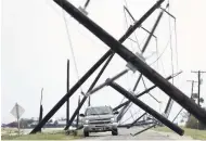  ?? AP ?? A driver works his way through a maze of fallen utility poles damaged in the wake of Hurricane Harvey on Saturday, August 26 in Taft, Texas.