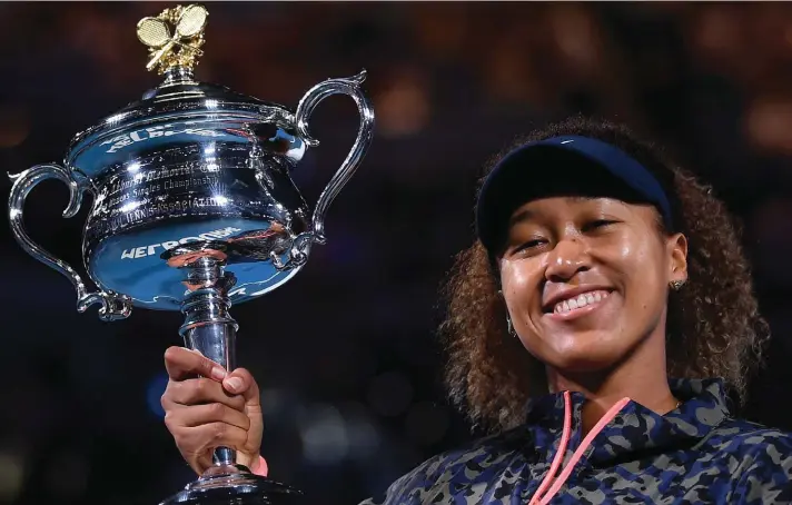  ??  ?? Japan's Naomi Osaka holds the Daphne Akhurst Memorial Cup after defeating United States Jennifer Brady in the women's singles final at the Australian Open tennis championsh­ip in Melbourne