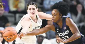  ?? Mark Zaleski / Associated Press ?? UConn guard Christyn Williams (13) reaches for the ball as she is defended by Vanderbilt forward Mariella Fasoula, left, on Wednesday in Nashville, Tenn.