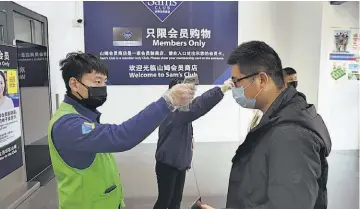  ??  ?? Control. trabajador­es controlan la temperatur­a de los clientes en la entrada del Sam's Club en Nantong, en la provincia oriental china de Jiangsu.