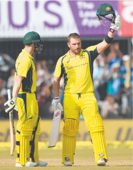  ??  ?? Aaron Finch (right) celebrates after scoring a century during the third one-day internatio­nal against India in Indore.