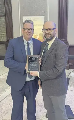  ?? ?? Nairn Golf Club’s Michael Mcallan, right, is presented with a plaque to mark being the PGA in Scotland Nominee for the 2023 Toby Sunderland Award by PGA in Scotland chairman Jason Boyd