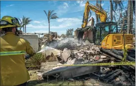  ?? PHOTO BY JEFF ANTENORE ?? A firefighte­r extinguish­es hot spots as one of his colleagues uses heavy equipment to demolish a destroyed home on Coronado Pointe in Laguna Niguel on Saturday.