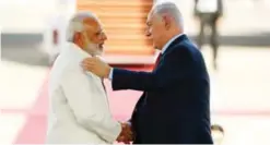  ?? — AFP ?? TEL AVIV: Israeli Prime Minister Benjamin Netanyahu (right) greets his Indian counterpar­t Narendra Modi during an official ceremony at Ben-Gurion Internatio­nal airport yesterday.