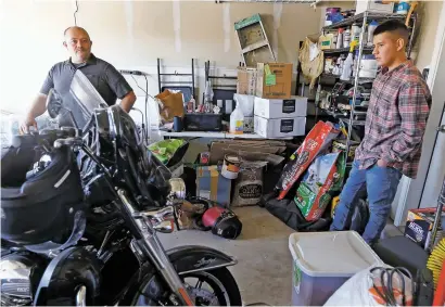  ?? LUIS SÁNCHEZ SATURNO/THE NEW MEXICAN ?? Paul Arellano of Santa Fe hangs out in the garage with his adopted son Gabe Arellano, 15, on Tuesday. Gabe was adopted by Arellano when he was a fourth grader. ‘A lot of kids are not as fortunate as me to get adopted young,’ Gabe said.