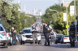  ?? ANTHONY VAZQUEZ/ SUN-TIMES FILE ?? LEFT: Police investigat­e the scene of the shooting near the corner of Grand and Merrimac avenues.