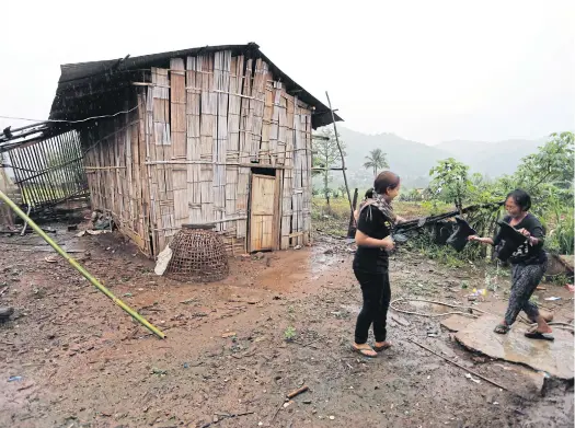  ??  ?? THE SIMPLE LIFE: A Lahu woman cleans her boots after collecting vegetables.