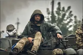  ?? KOSTIANTYN LIBEROV — THE ASSOCIATED PRESS ?? A Ukrainian soldier atop a military vehicle on the road in the freed territory of the Kharkiv region, Ukraine, on Monday.