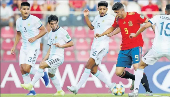  ??  ?? Escobar, delantero del Valencia y de la Selección Española Sub-17, intenta zafarse del marcaje de los jugadores argentinos Fernández y Medina, durante el partido de ayer.