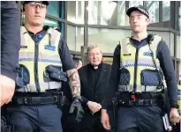  ?? Picture / AP ?? Cardinal George Pell was protected by police as he entered and left court on Wednesday.
