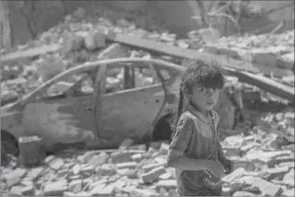  ?? FELIPE DANA, THE ASSOCIATED PRESS ?? An Iraqi girl flees through a destroyed street Sunday in Mosul, Iraq. American-backed forces are tightening their grip on the Syrian city of Raqqa.