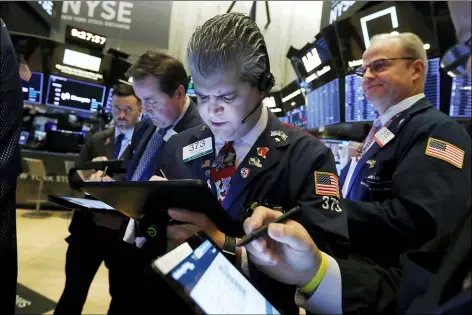  ?? RICHARD DREW — THE ASSOCIATED PRESS ?? John Panin, center, works with fellow traders on the floor of the New York Stock Exchange, Thursday.