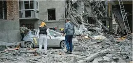  ?? SERGEY BOBOK/GETTY-AFP ?? Ukrainians examine the damage to an apartment building after a missile strike Tuesday in Kharkiv.