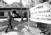  ?? PHOTO: REUTERS ?? A policeman guards a polling station in Colombo during the presidenti­al election in Sri Lanka