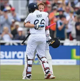  ?? ?? Ollie Pope receives a big hug from Joe Root after reaching his century at Trent Bridge yesterday