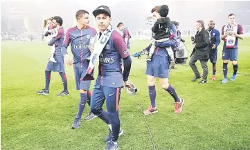  ?? — AFP photo ?? Paris Saint-Germain’s forward Neymar (centre) walks on the pitch with teammates after winning the French Ligue 1 title at the end of the league match against Rennes at The Parc des Princes Stadium in Paris.