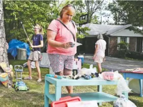  ?? STAFF PHOTO BY ERIN O. SMITH ?? Hannah DeBey, Raylene Froman and Malinda DeBey, from left, look at items Thursday at one stop along the World’s Longest Yard Sale on Highway 127 in Signal Mountain. The three are relatives who come from Maryland, Colorado and Texas, respective­ly, and met up in Chattanoog­a for a girls weekend.