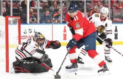  ?? | JOEL AUERBACH/ GETTY IMAGES ?? Blackhawks goaltender Corey Crawford pokes the puck away from Jonathan Huberdeau of the Panthers.