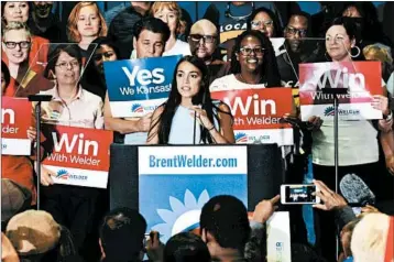  ?? LUKE HARBUR/KANSAS CITY STAR ?? Alexandria Ocasio-Cortez rides her upset in the New York primary to campaign Friday for Kansas Democrat Brent Welder.