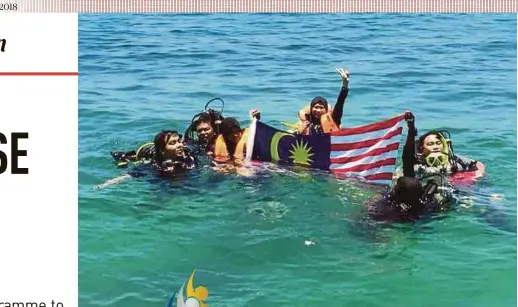  ?? PIC BY SYAHID SOKRI ?? Participan­ts of the Merdeka Marine Conservati­on Programme 2018 planting the Jalur Gemilang in the waters off Pulau Bidan, Yan, yesterday.